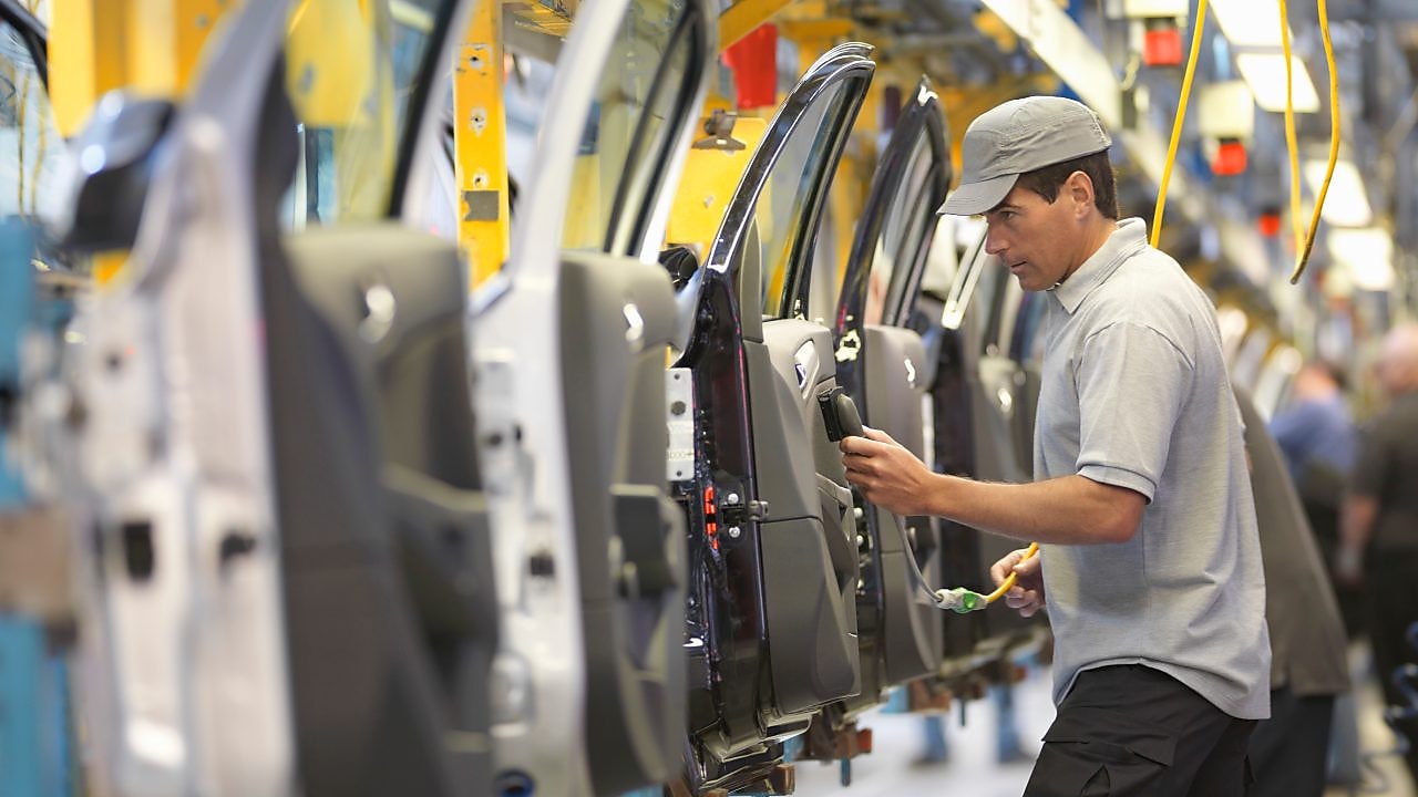 Man holding wire looking at machine