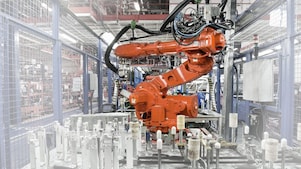 A red robotic arm in a factory