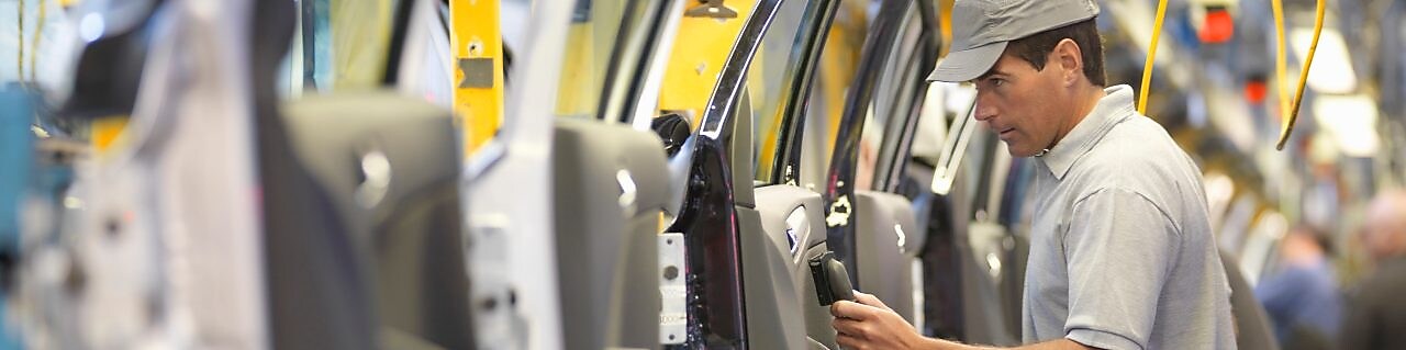 man holding wire looking at machine