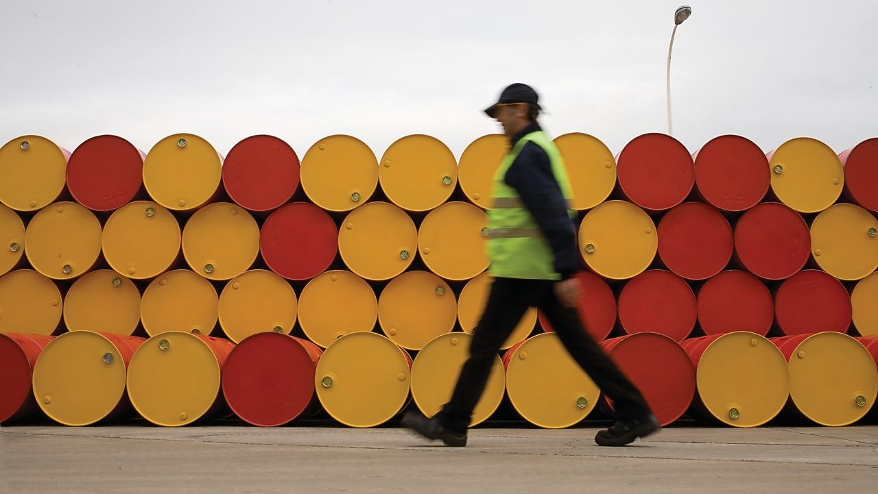 man walking barrels lubricants