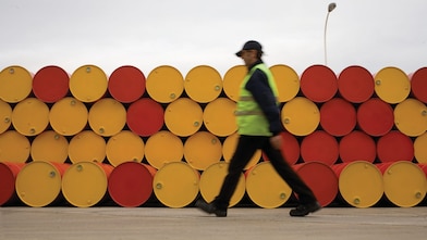 man walking barrels lubricants