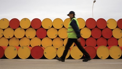 Man walking barrels lubricants