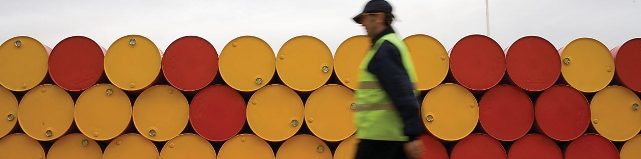 man walking barrels lubricants